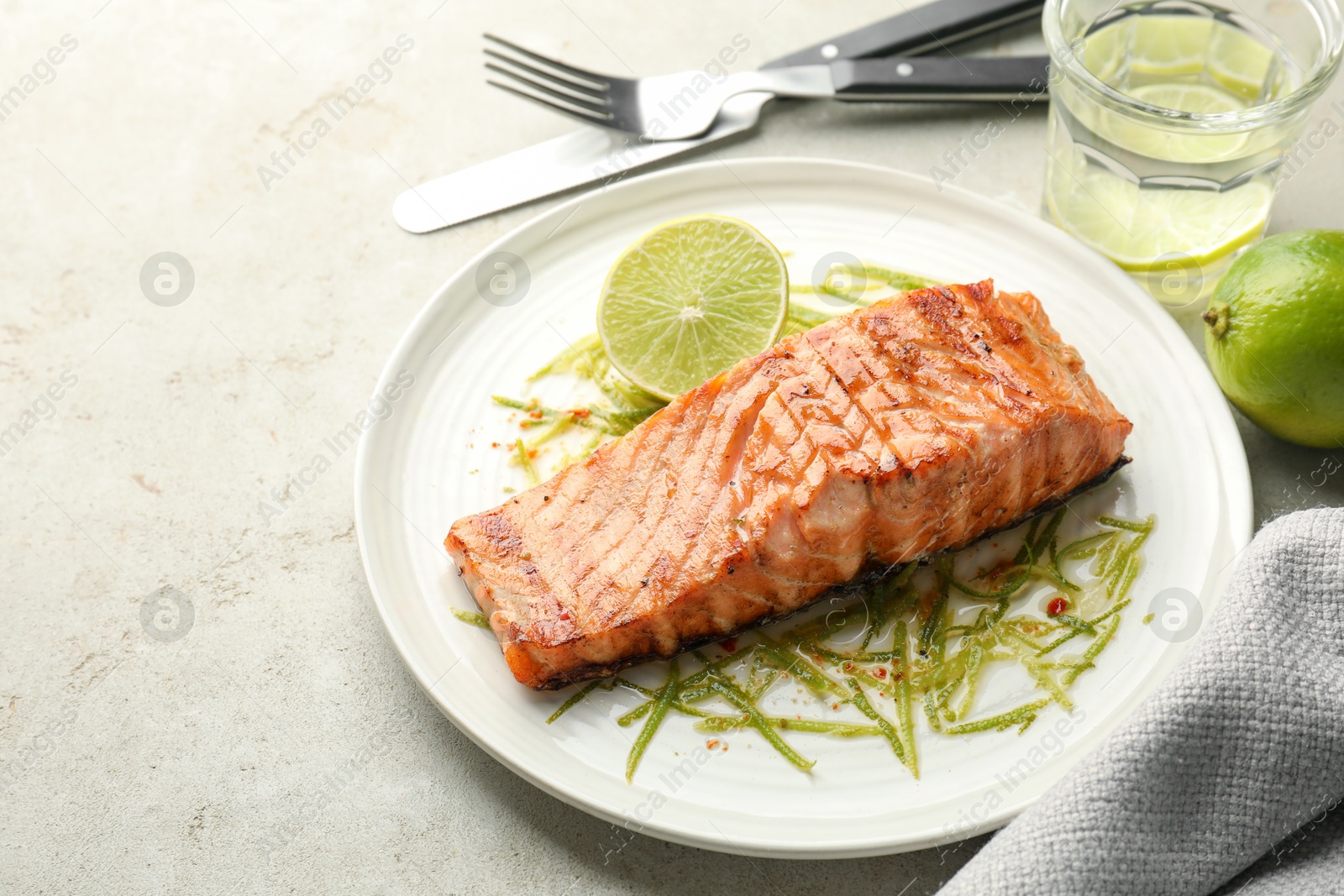 Photo of Delicious grilled salmon fillet served on light table