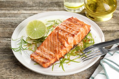 Photo of Delicious grilled salmon fillet served on wooden table, closeup