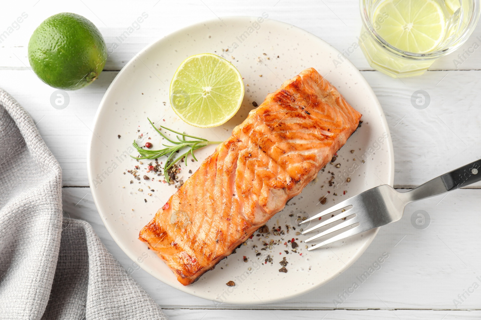 Photo of Delicious grilled salmon fillet served on white wooden table, flat lay