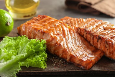 Photo of Delicious grilled salmon fillets served on grey table, closeup