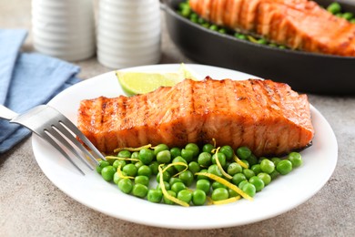 Photo of Delicious grilled salmon fillet served on grey textured table, closeup