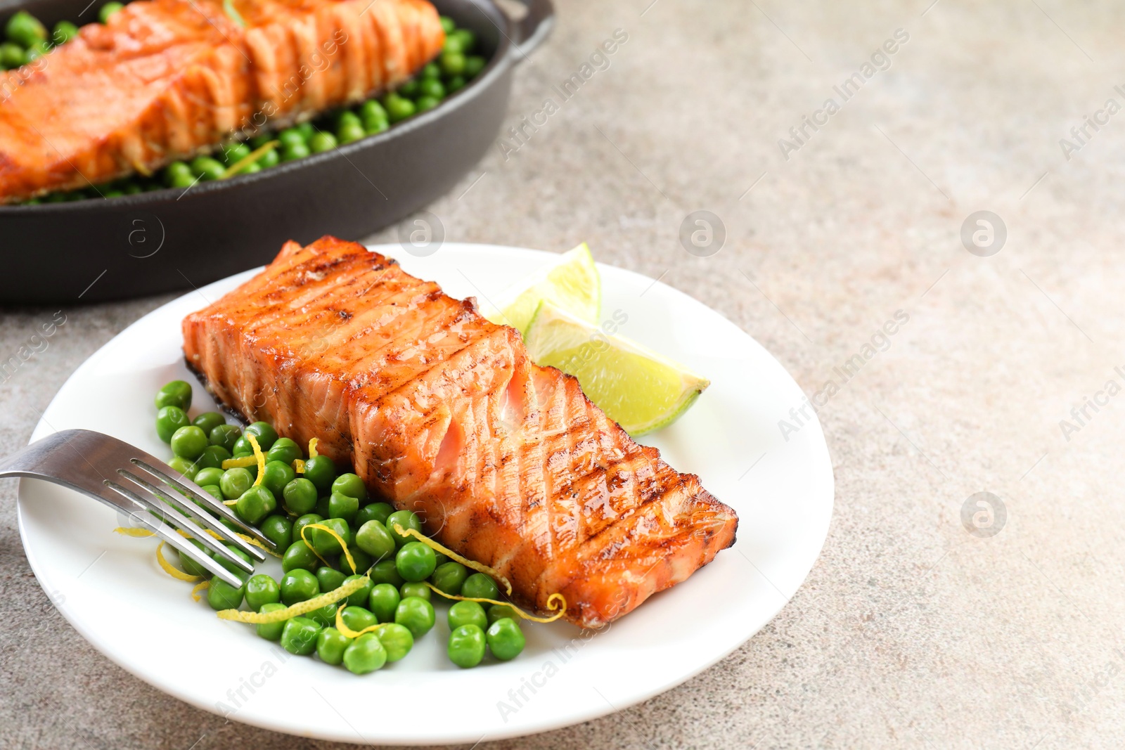 Photo of Delicious grilled salmon fillets served on grey textured table