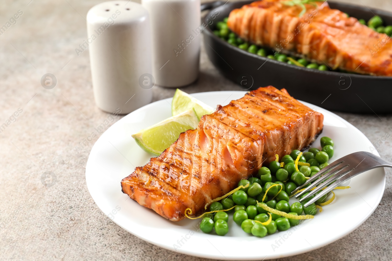 Photo of Delicious grilled salmon fillets served on grey textured table