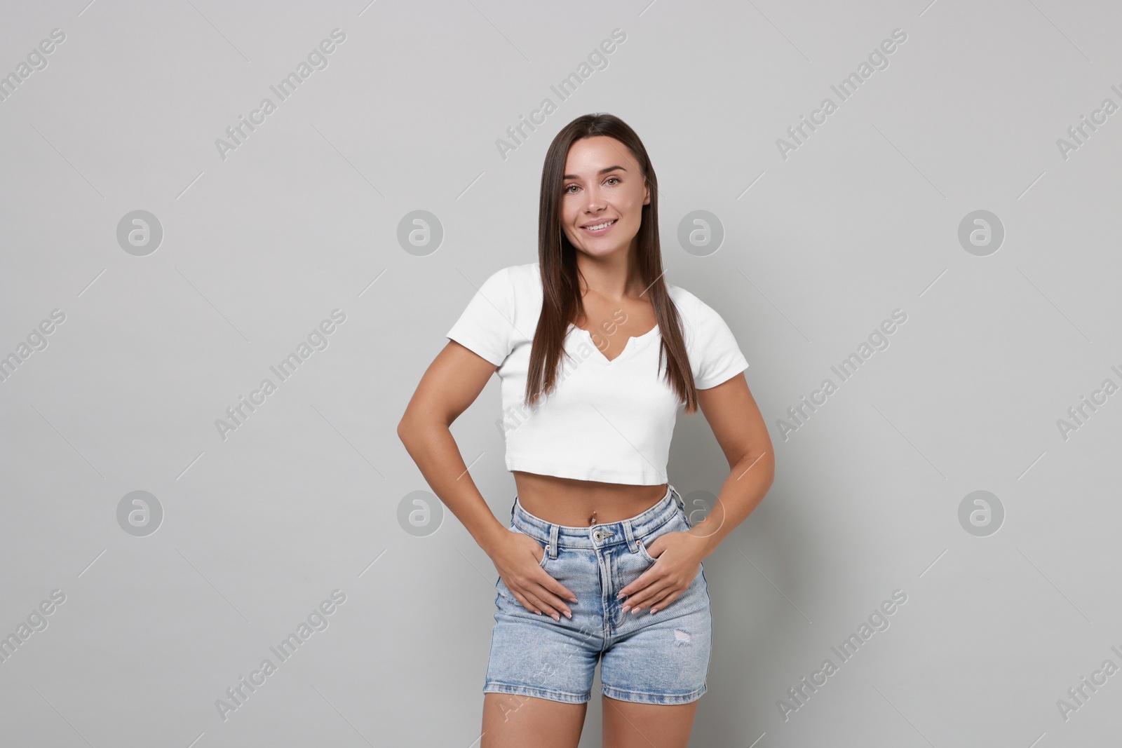 Photo of Beautiful woman wearing stylish denim shorts on gray background