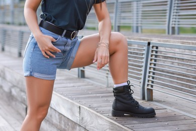 Photo of Woman wearing stylish denim shorts outdoors, closeup