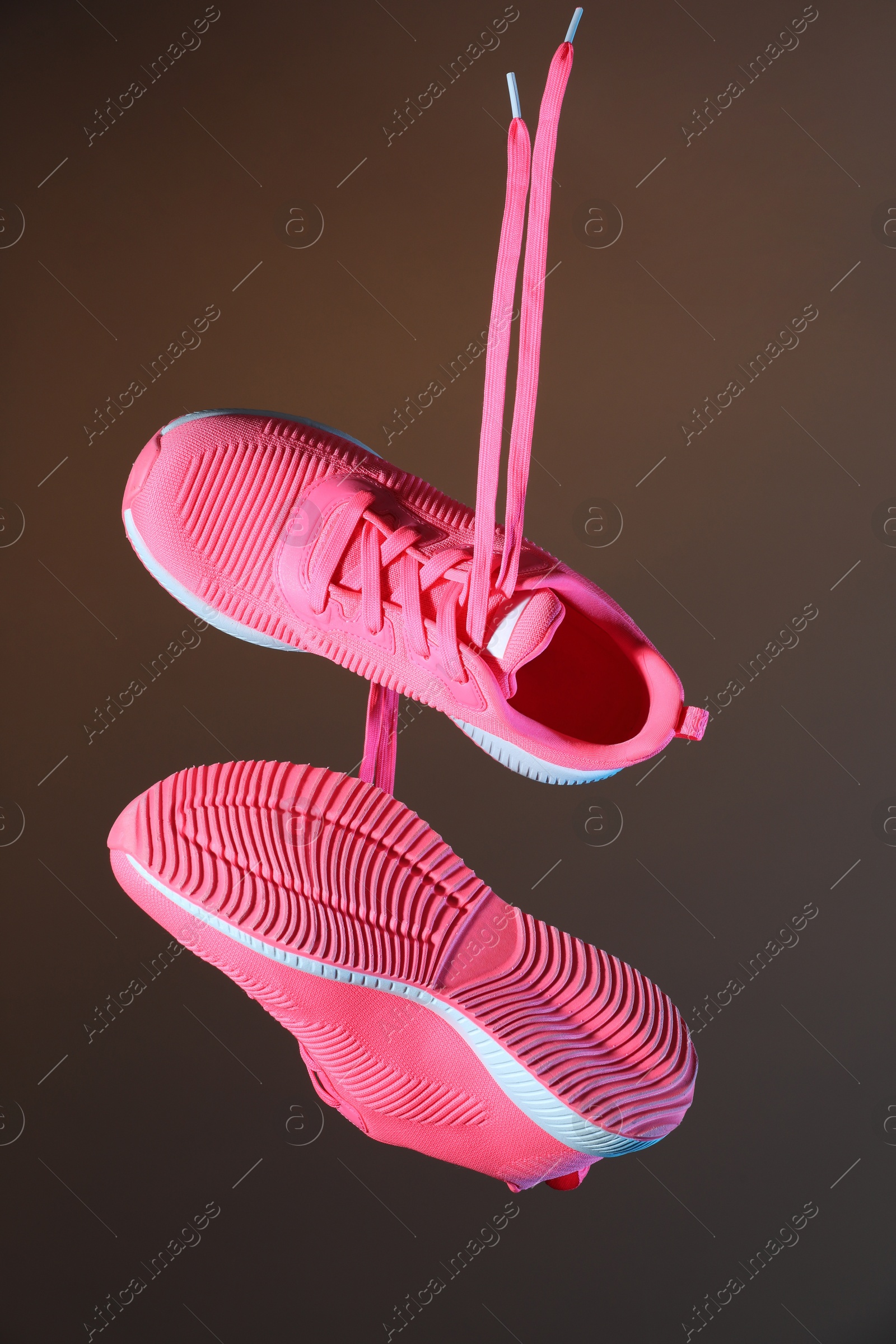 Photo of Pair of stylish sneakers in air against grey background