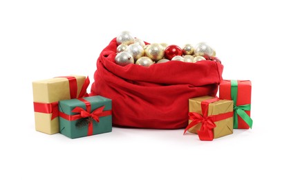 Photo of Red Santa Claus bag with baubles and gift boxes isolated on white