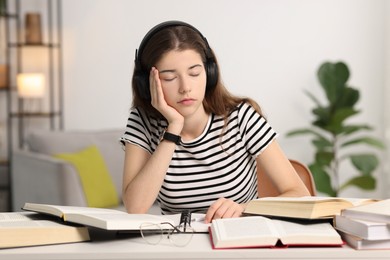 Photo of Preparing for exam. Tired student sleeping at table indoors