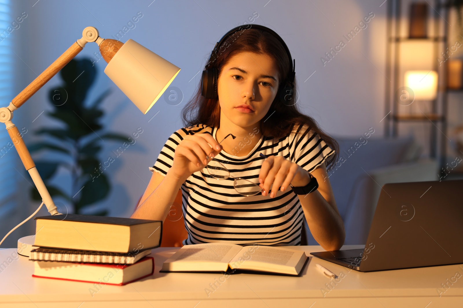 Photo of Preparing for exam. Student with books at table indoors