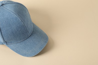 Photo of Stylish denim baseball cap on beige background. Mockup for design