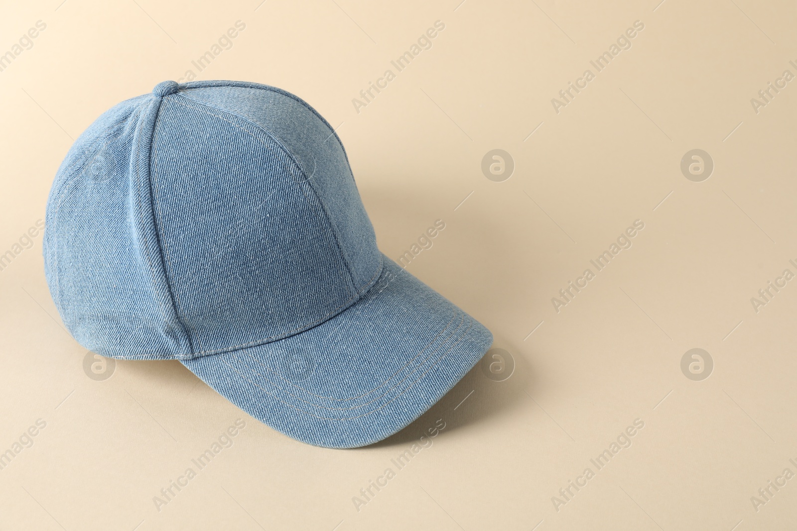 Photo of Stylish denim baseball cap on beige background. Mockup for design