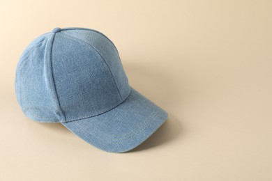 Photo of Stylish denim baseball cap on beige background. Mockup for design