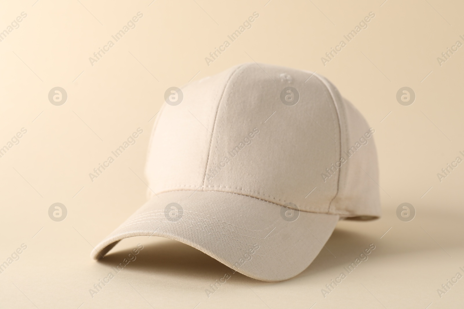 Photo of Stylish baseball cap on beige background, closeup. Mockup for design