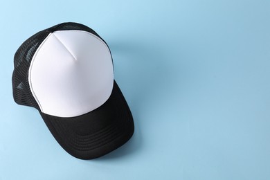 Photo of Stylish baseball cap on light blue background, above view. Mockup for design