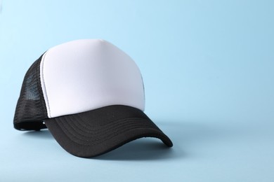 Photo of Stylish baseball cap on light blue background. Mockup for design