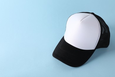 Photo of Stylish baseball cap on light blue background. Mockup for design