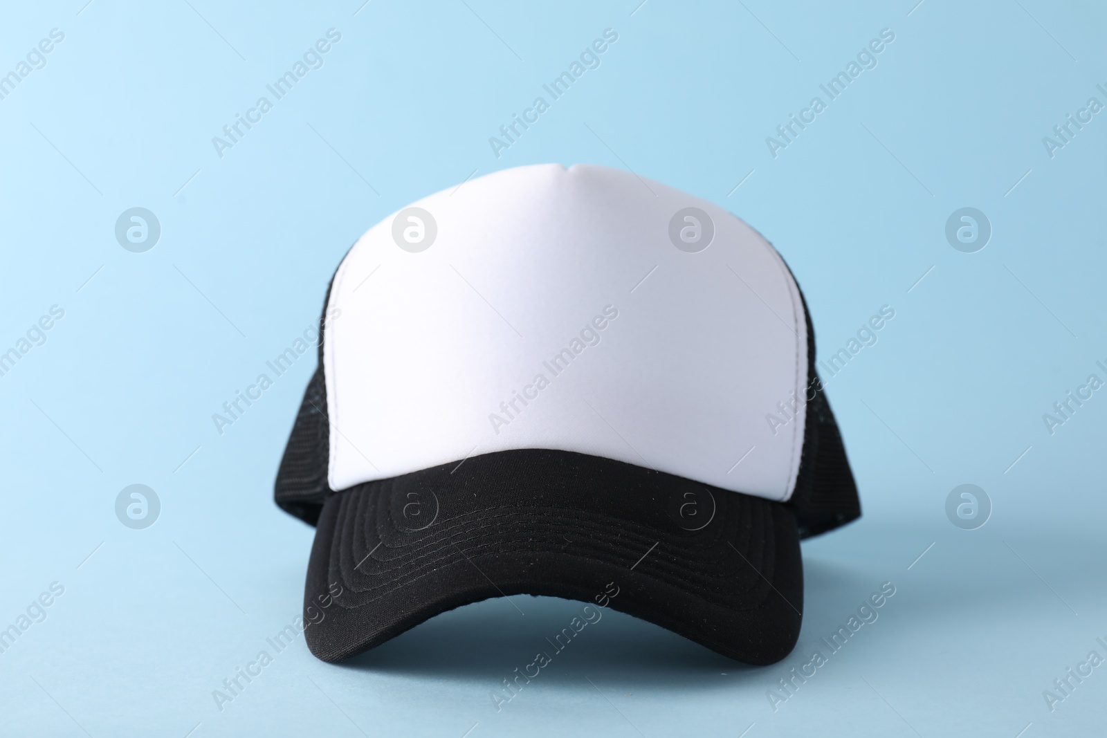 Photo of Stylish baseball cap on light blue background, closeup. Mockup for design