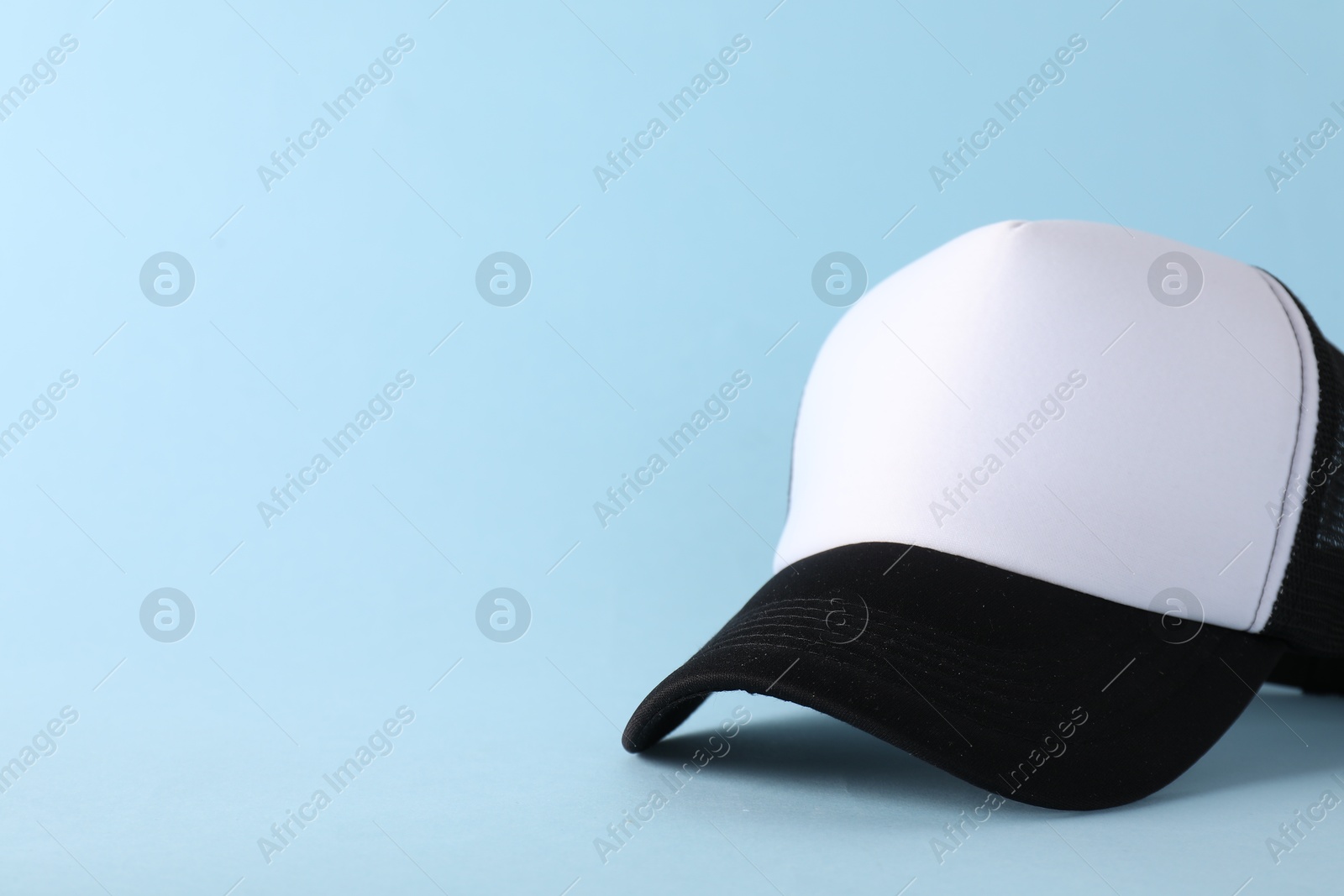 Photo of Stylish baseball cap on light blue background. Mockup for design