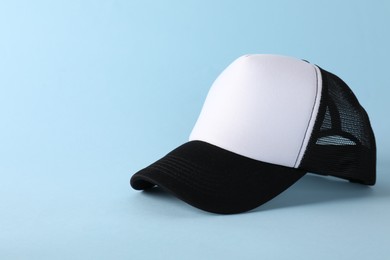 Photo of Stylish baseball cap on light blue background. Mockup for design