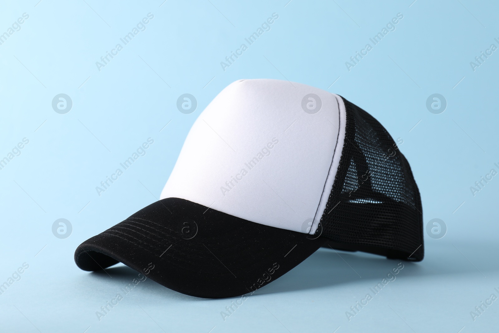 Photo of Stylish baseball cap on light blue background. Mockup for design