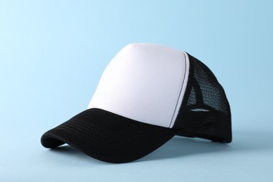 Photo of Stylish baseball cap on light blue background. Mockup for design