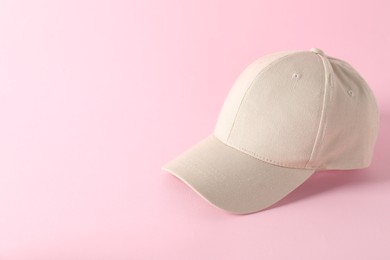 Photo of Stylish baseball cap on pink background. Mockup for design