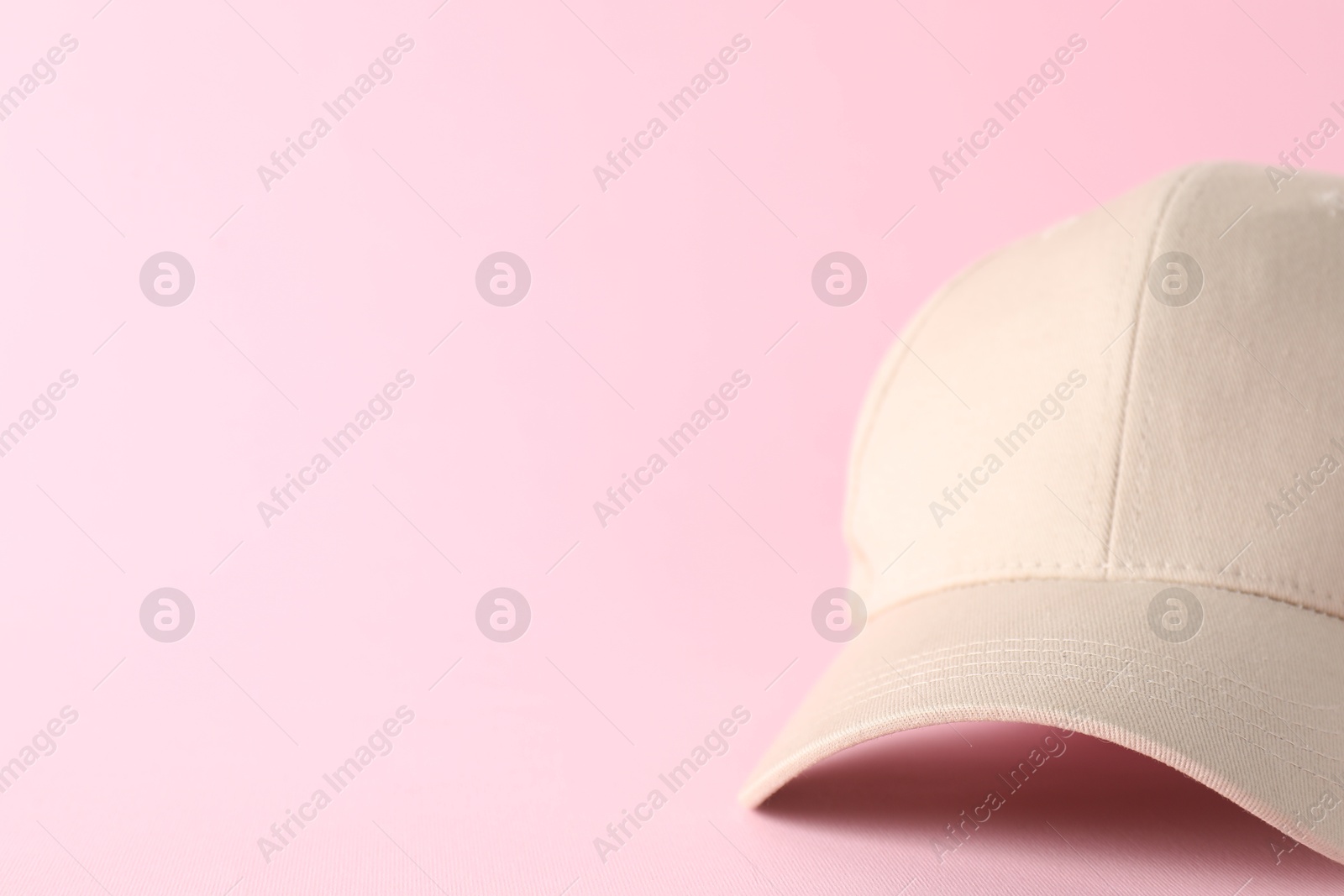 Photo of Stylish baseball cap on pink background, closeup. Mockup for design