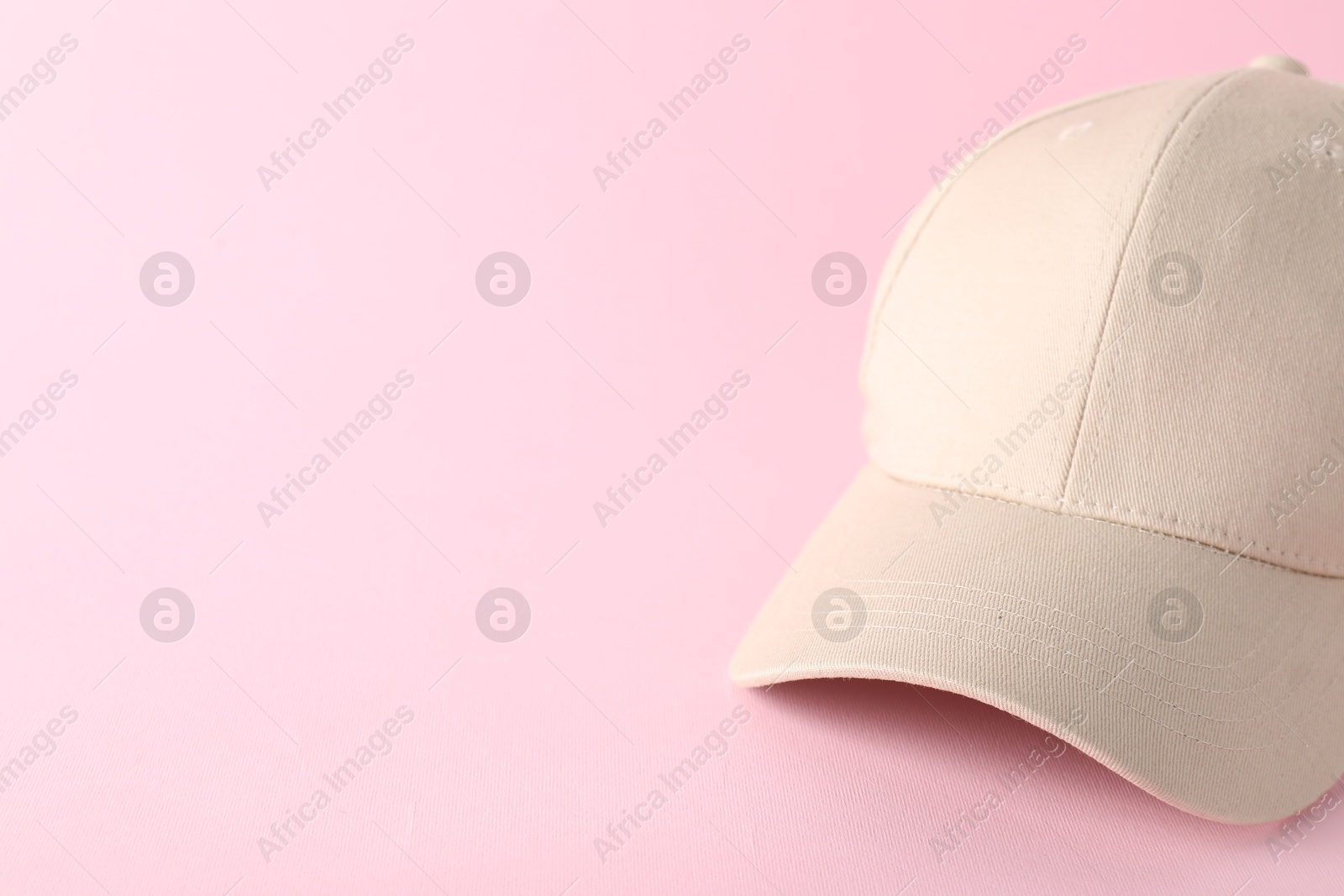 Photo of Stylish baseball cap on pink background, closeup. Mockup for design