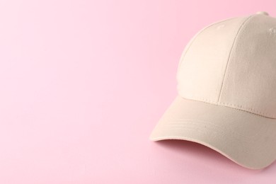 Photo of Stylish baseball cap on pink background, closeup. Mockup for design