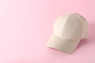 Photo of Stylish baseball cap on pink background. Mockup for design