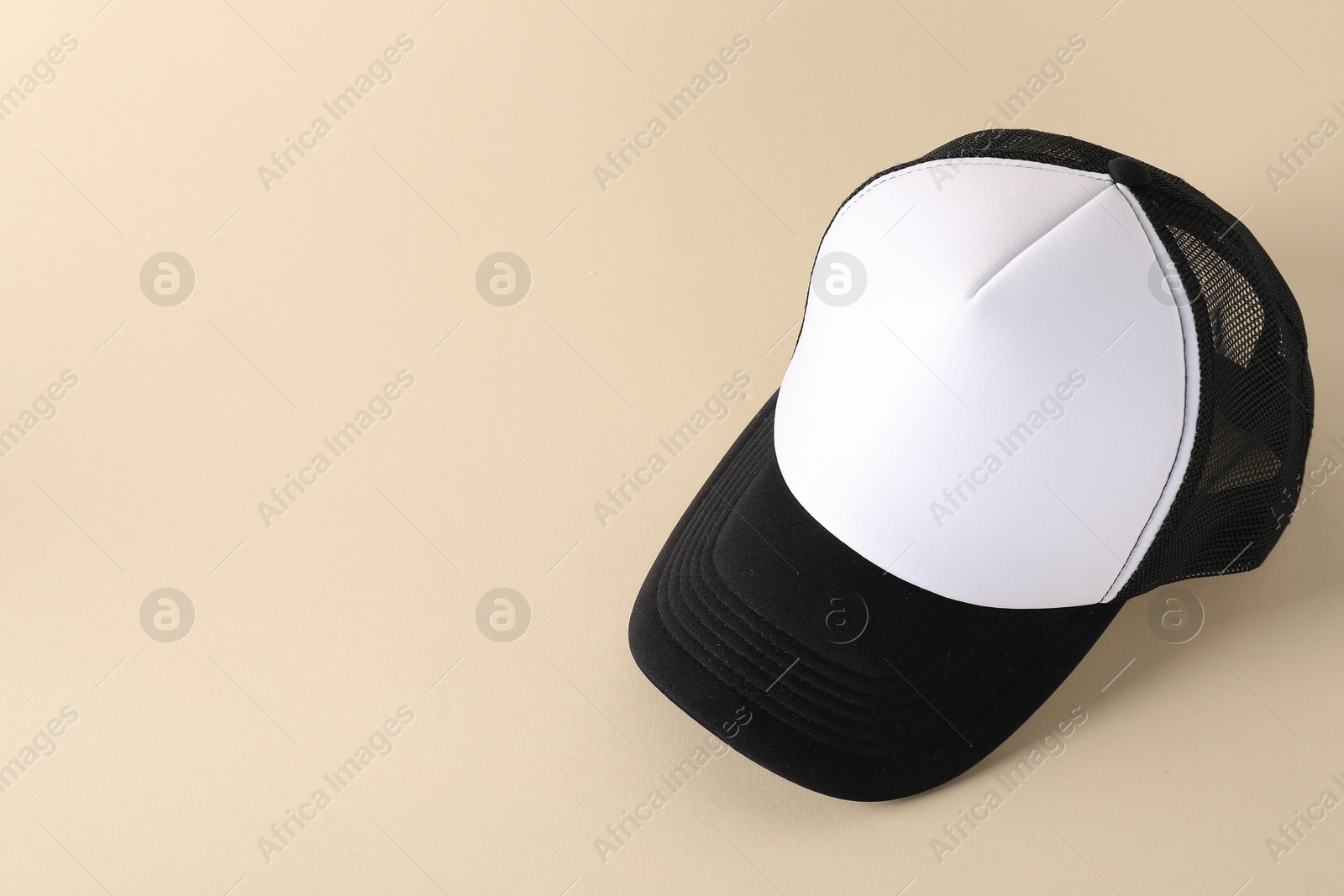 Photo of Stylish baseball cap on beige background. Mockup for design