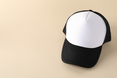 Photo of Stylish baseball cap on beige background. Mockup for design