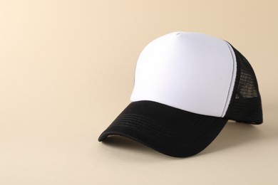 Photo of Stylish baseball cap on beige background. Mockup for design