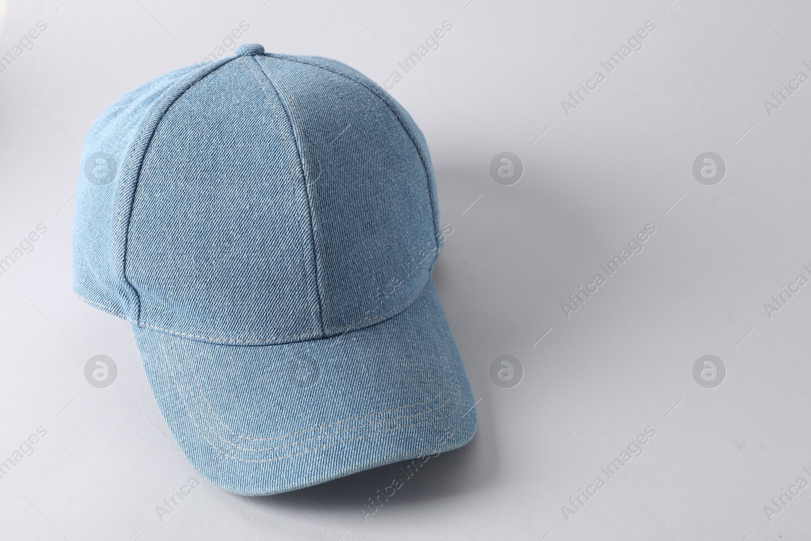 Photo of Stylish denim baseball cap on light grey background. Mockup for design