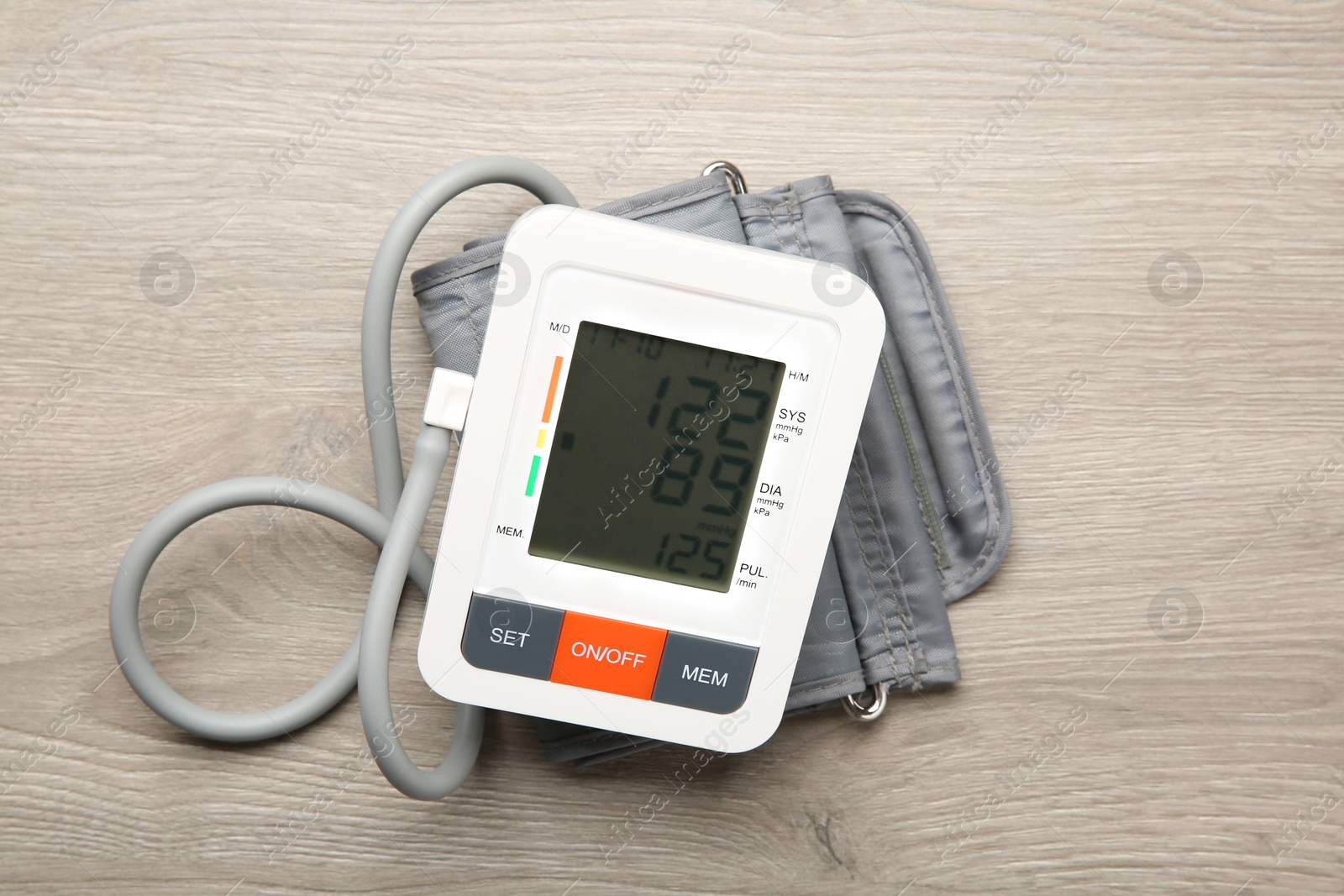 Photo of Blood pressure measuring device on wooden table, top view