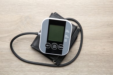 Photo of Blood pressure measuring device on wooden table, top view