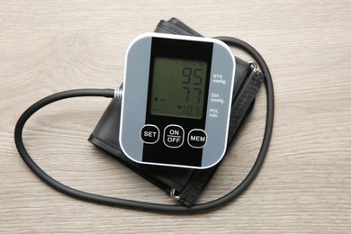 Photo of Blood pressure measuring device on wooden table, top view