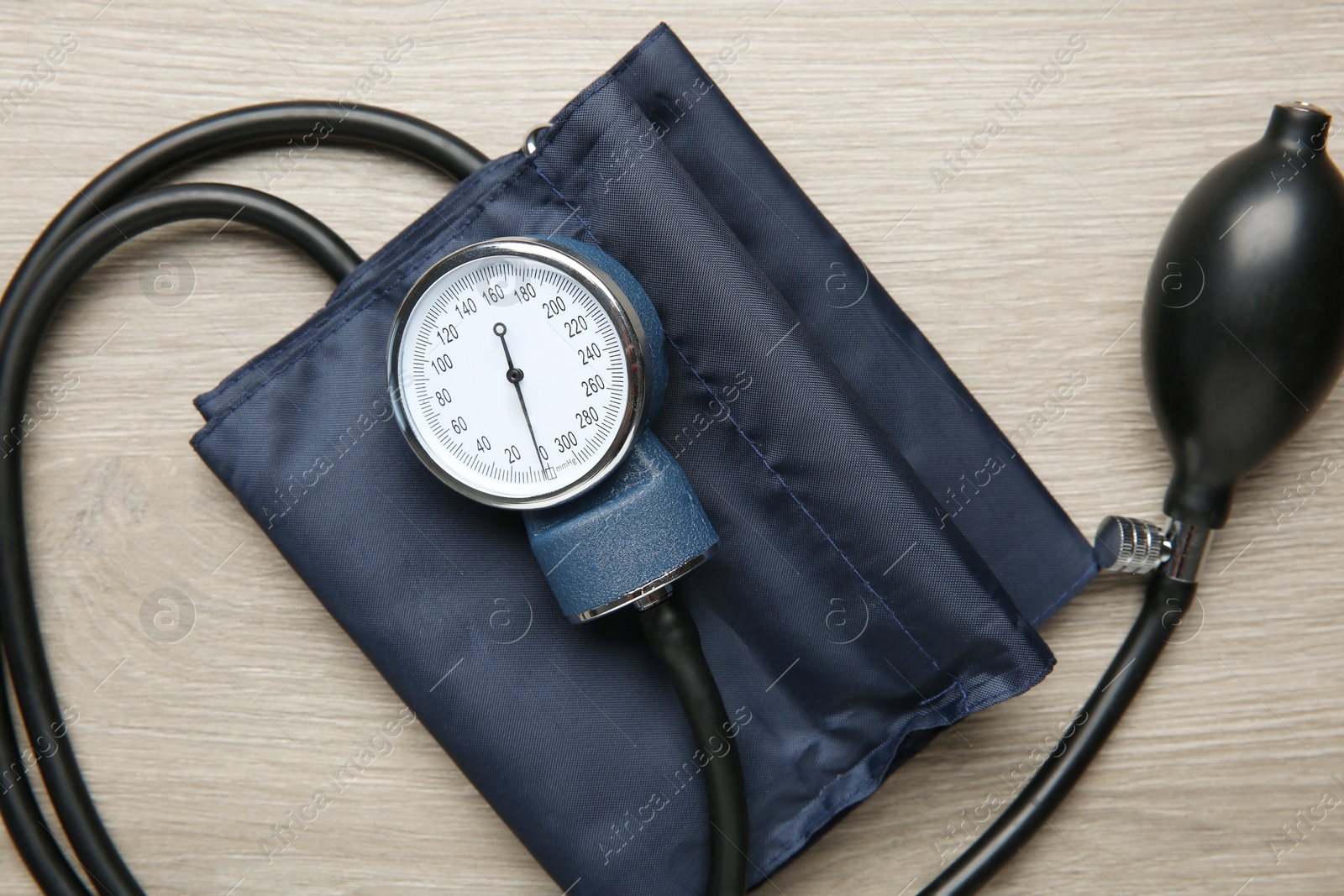 Photo of Blood pressure measuring device on wooden table, top view