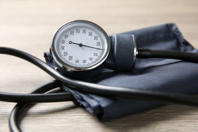 Photo of Blood pressure measuring device on wooden table, closeup