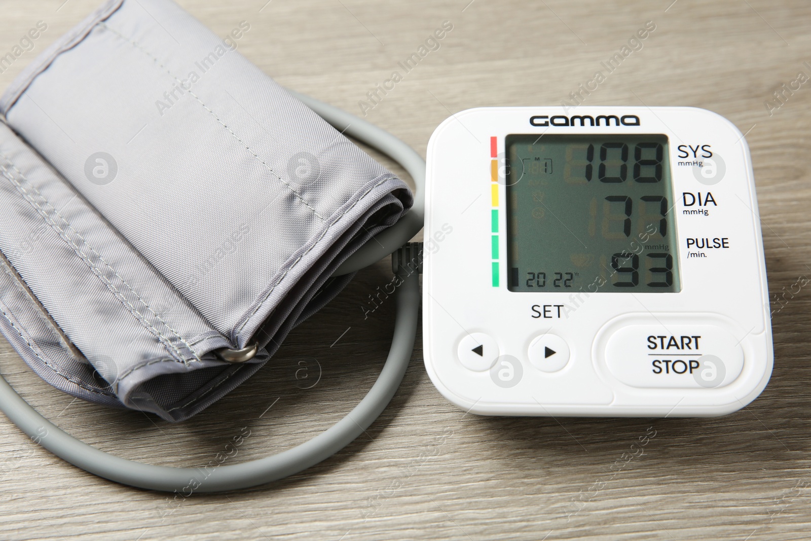 Photo of Blood pressure measuring device on wooden table, closeup