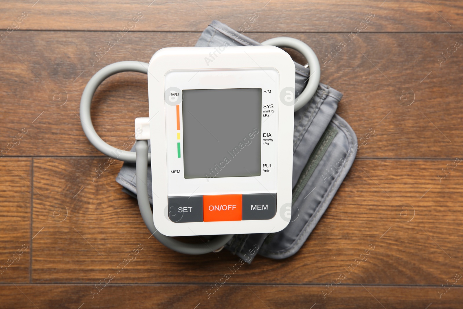 Photo of Blood pressure measuring device on wooden table, top view