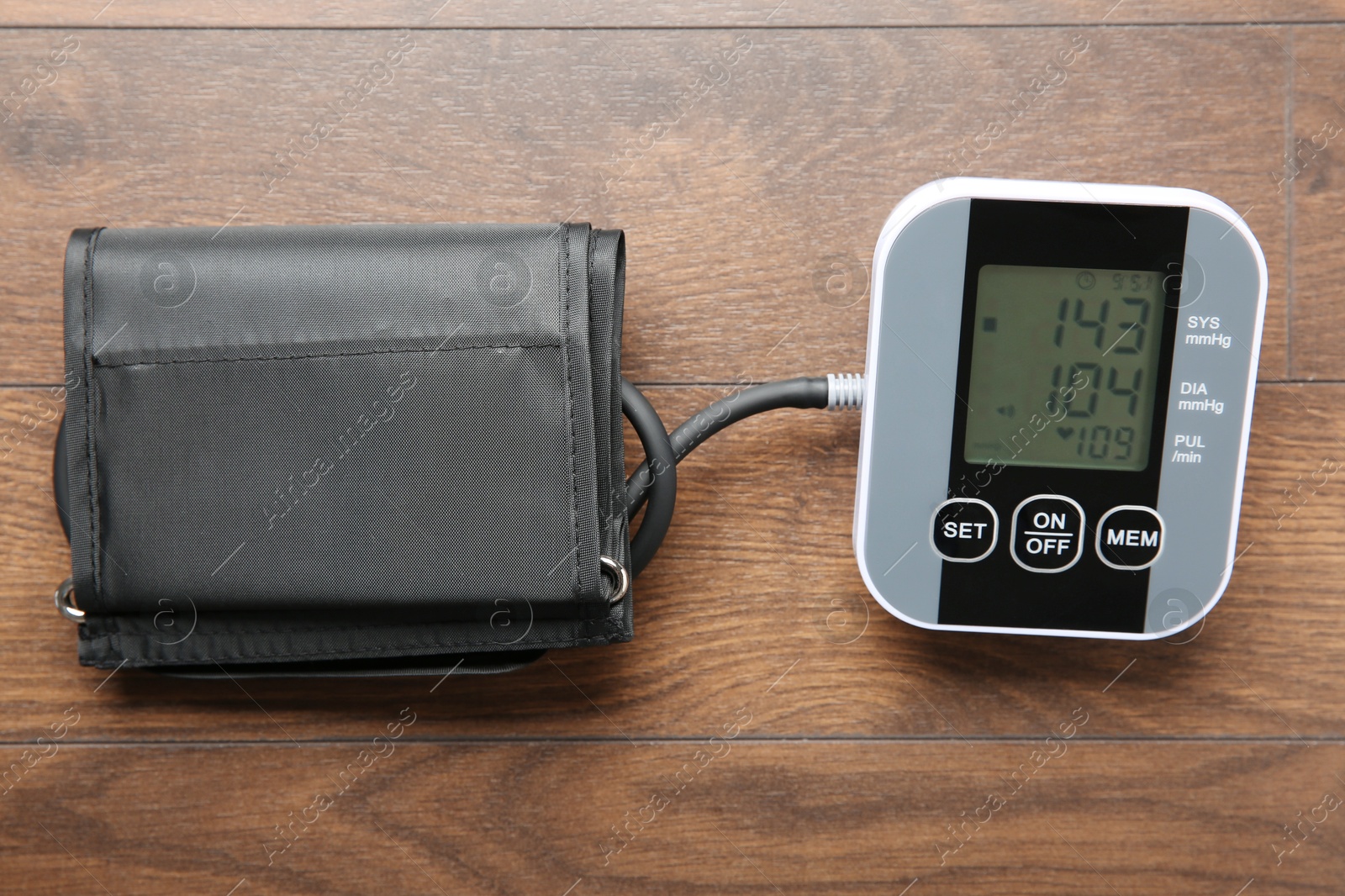 Photo of Blood pressure measuring device on wooden table, top view