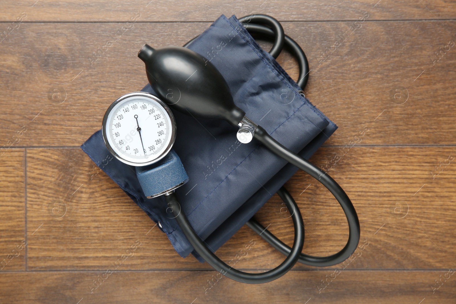 Photo of Blood pressure measuring device on wooden table, top view