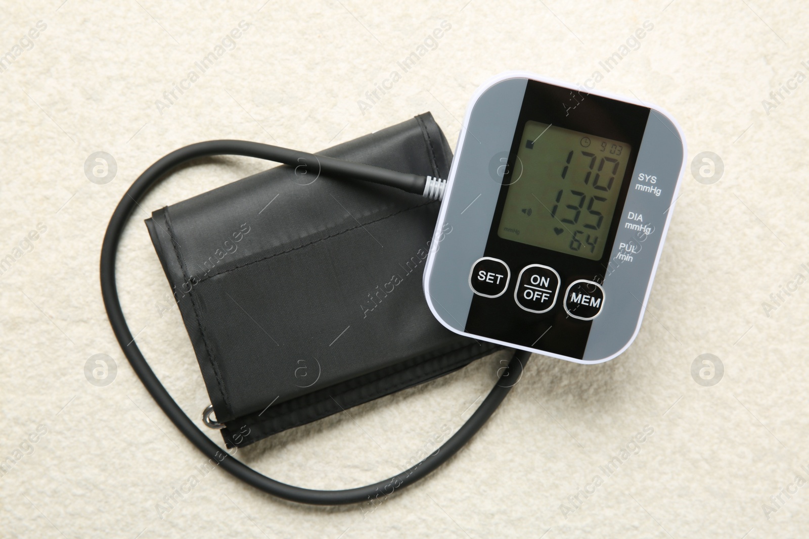 Photo of Blood pressure measuring device on light textured background, top view