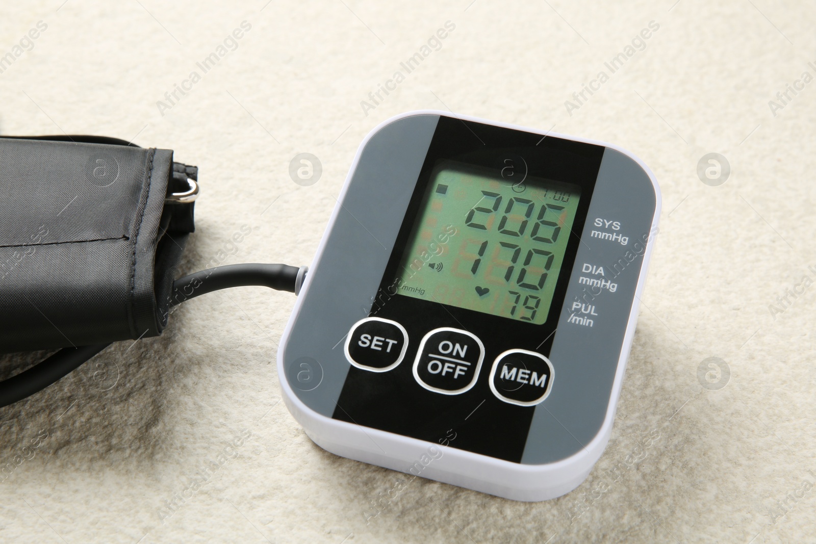 Photo of Blood pressure measuring device on light textured background, closeup