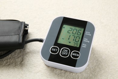 Blood pressure measuring device on light textured background, closeup