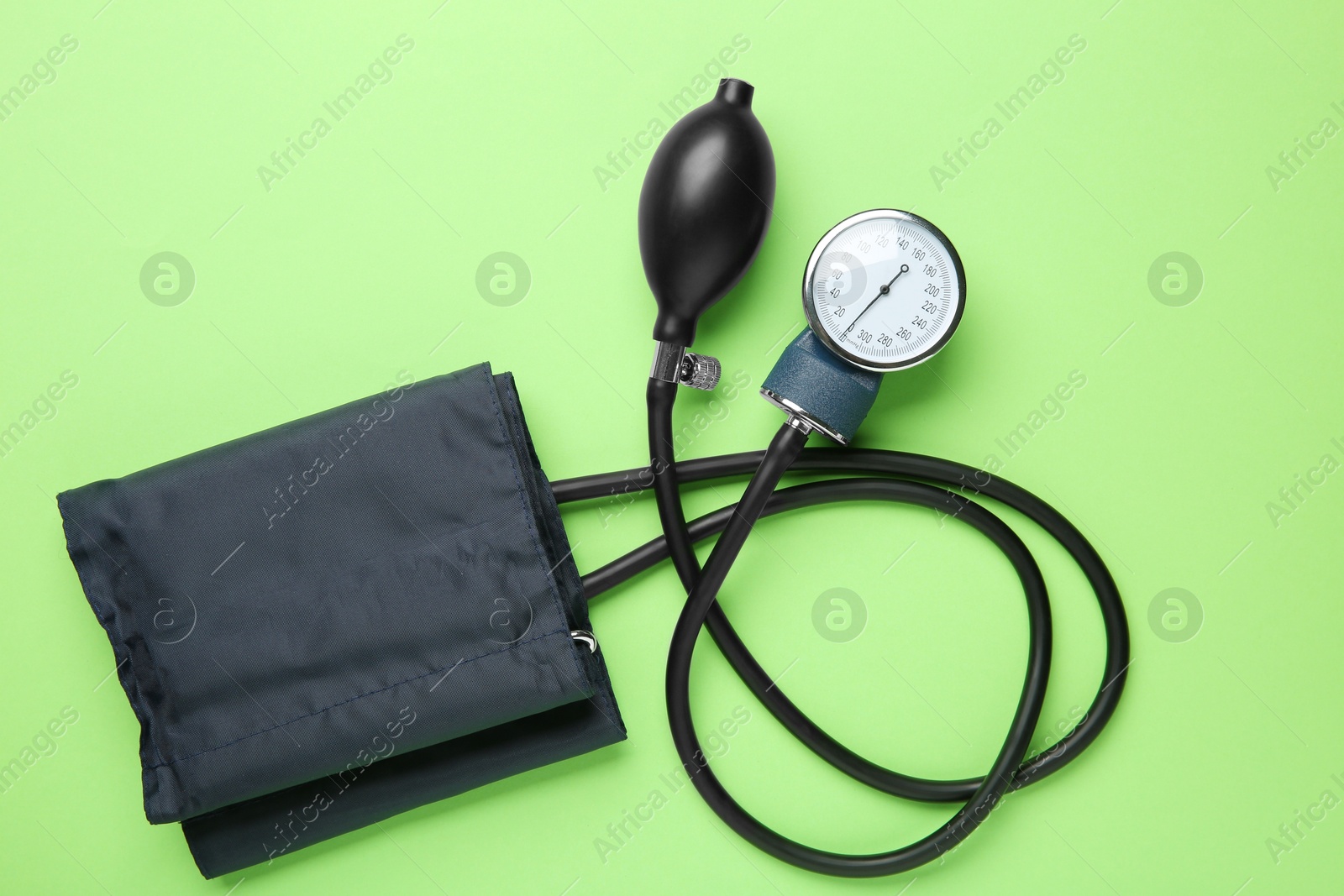 Photo of Blood pressure measuring device on green background, top view