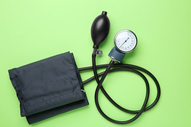 Photo of Blood pressure measuring device on green background, top view