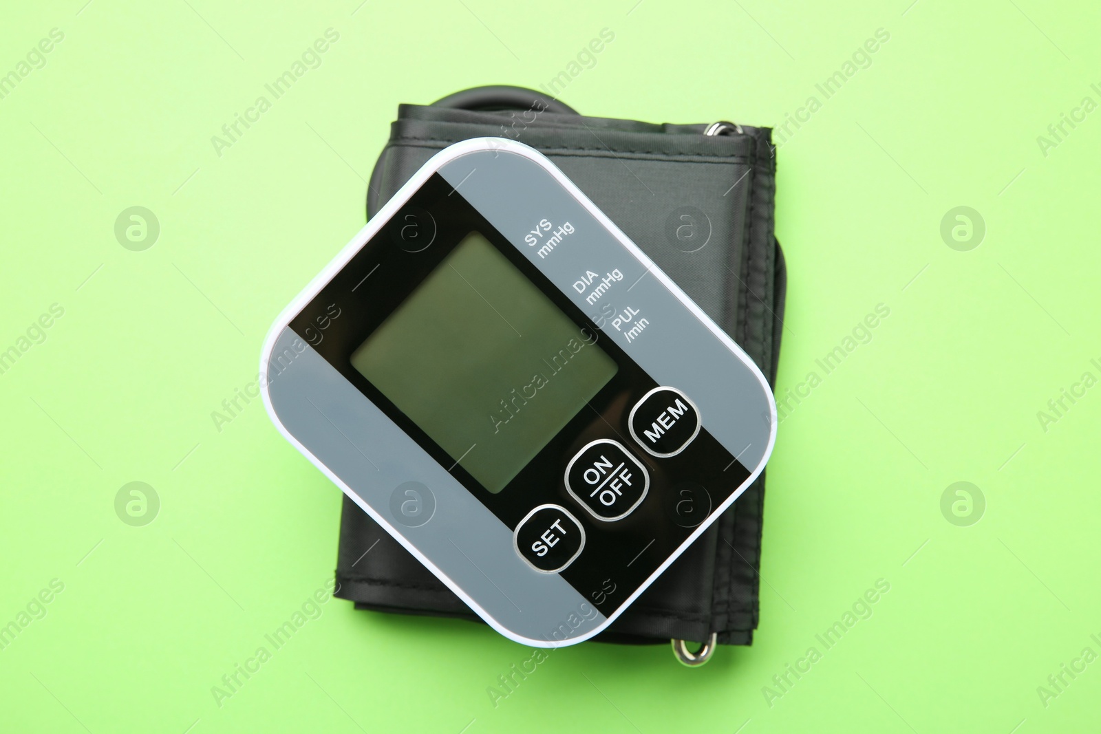 Photo of Blood pressure measuring device on green background, top view