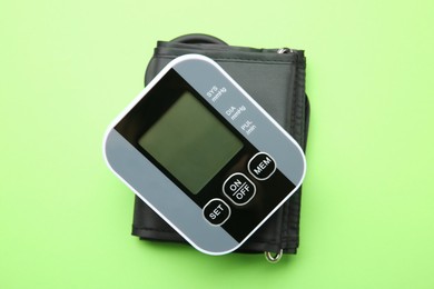 Photo of Blood pressure measuring device on green background, top view